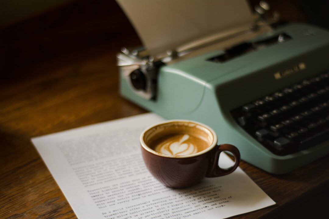 Writing desk with typewriter, notebooks and coffee cup