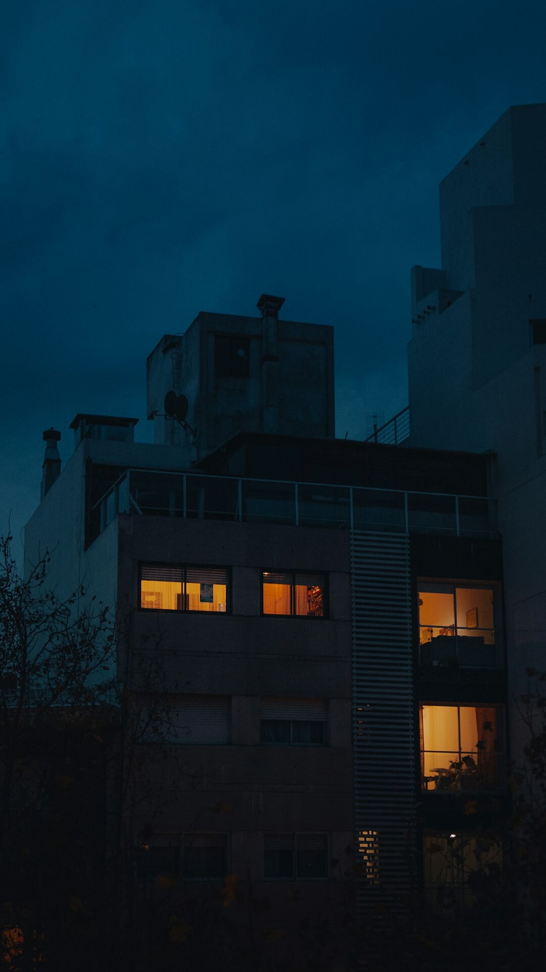 Rainy street in Montevideo at night with lit windows